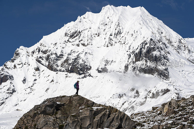 徒步旅行者在雪山下的山脊上休息