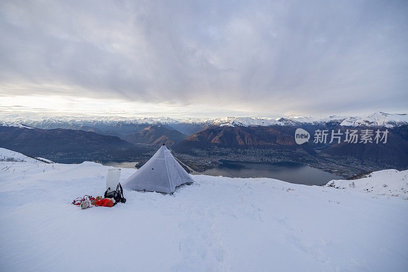 在雪地里露营，帐篷是建在一个湖、山脉之上的高峰上