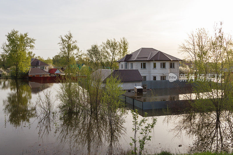 哈萨克斯坦发生洪灾。被淹的院子和别墅区的两层房子。河水溢出了堤岸。哈萨克斯坦的大灾难。