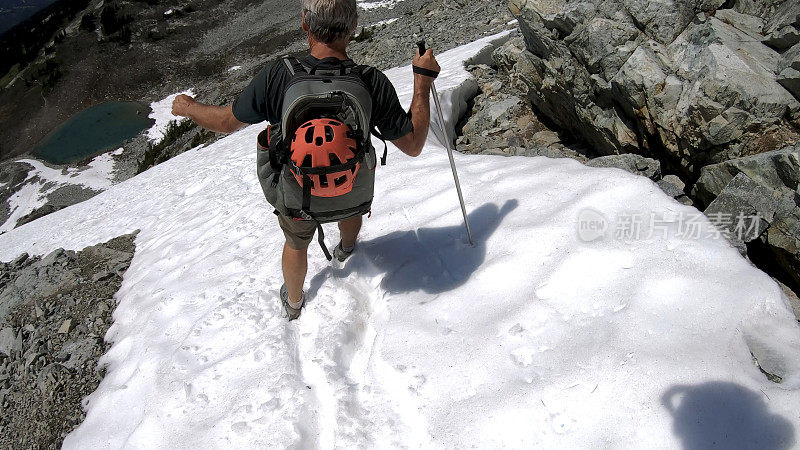 徒步旅行者沿着积雪的山坡跑下去