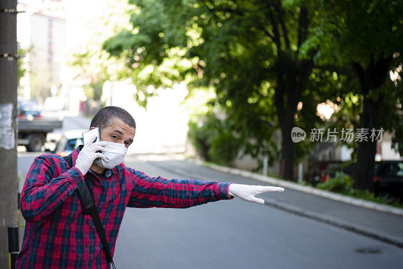 一个商人在疫情期间挥手赶出租车的肖像。