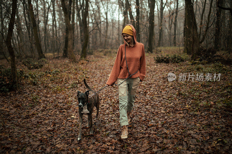 一个年轻的白人女人在遛狗