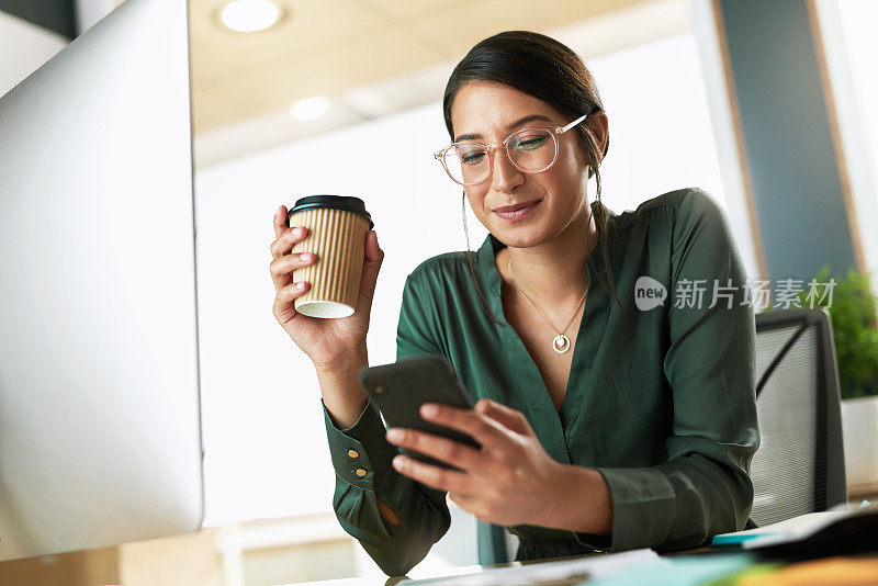 这是一位年轻女商人用智能手机发短信的照片