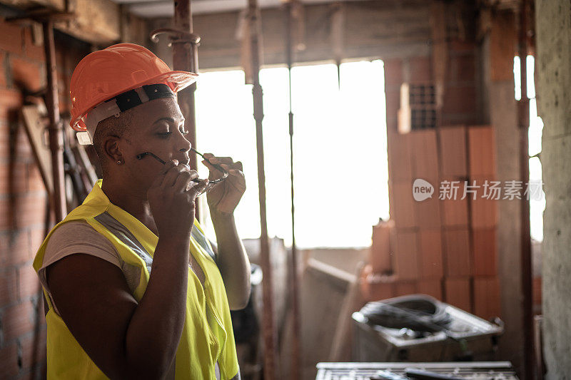 女建筑工人在建筑工地穿著工作服及防护服