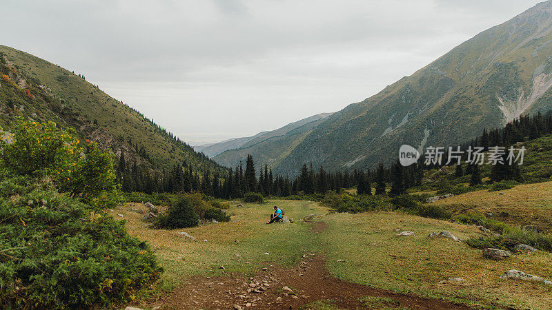 一名背包客在夏天的中亚山区徒步旅行