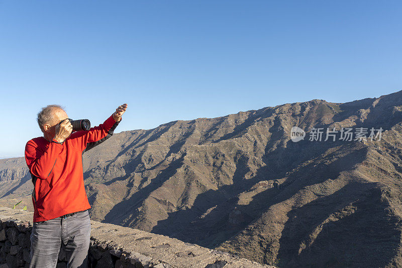 人们在拍摄加拉霍内山-拉戈梅拉山，背光与镜头光晕