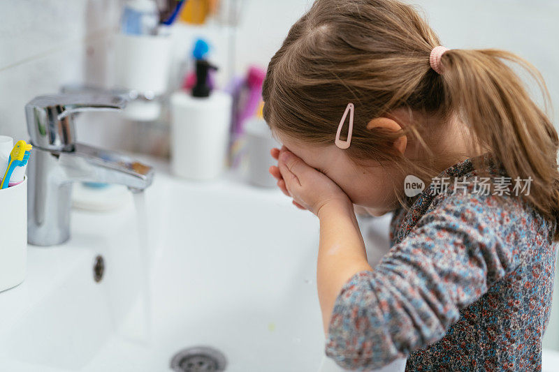 四岁的小女孩在浴室里洗脸