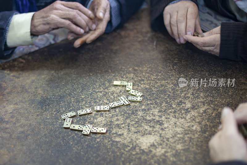 高级男子的手玩多米诺骨牌的特写照片