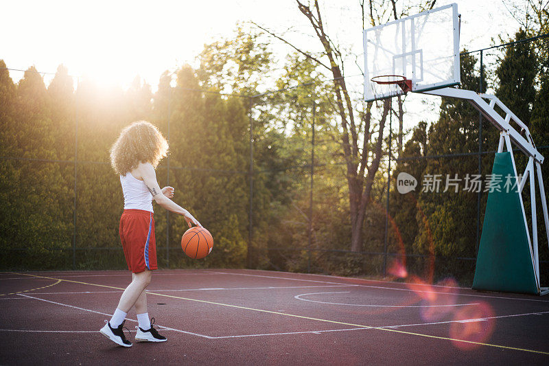 卷发女孩在外面打篮球