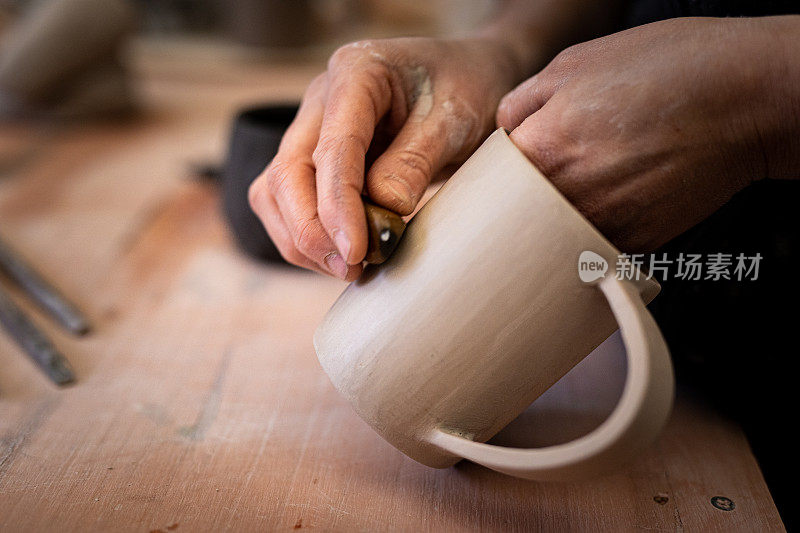 特写女人的手雕刻，打字和抛光一个粘土杯