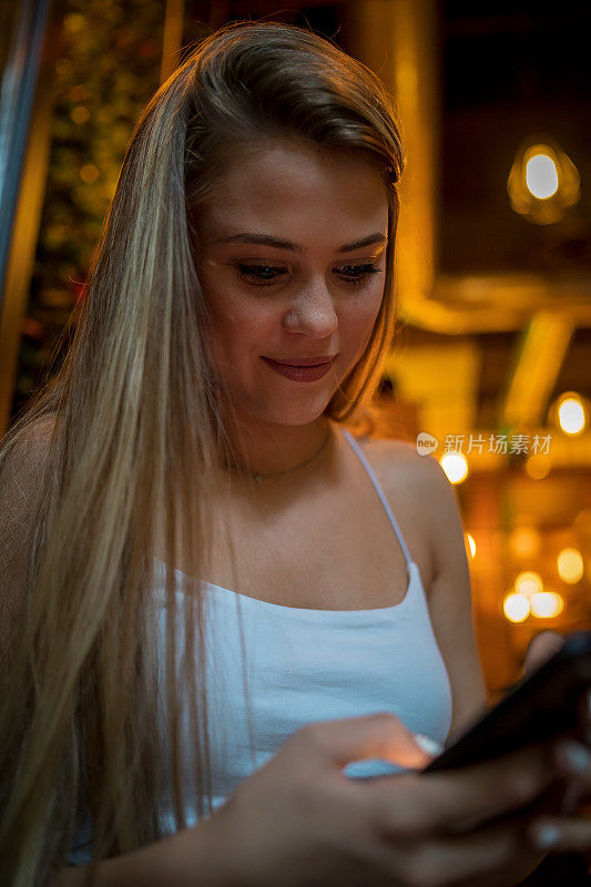 一名女性使用手机的照片，在Café