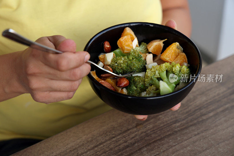 一名妇女正在吃一顿富含蔬菜和维生素的健康餐