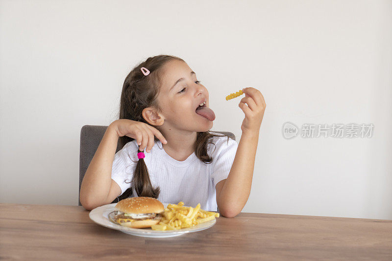 小女孩吃着一个大汉堡