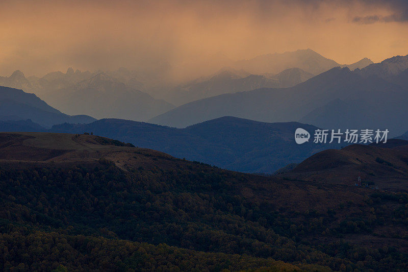 从俄罗斯厄尔布鲁斯地区的冈巴什山口，欣赏山脉山脊和山谷的壮丽日落