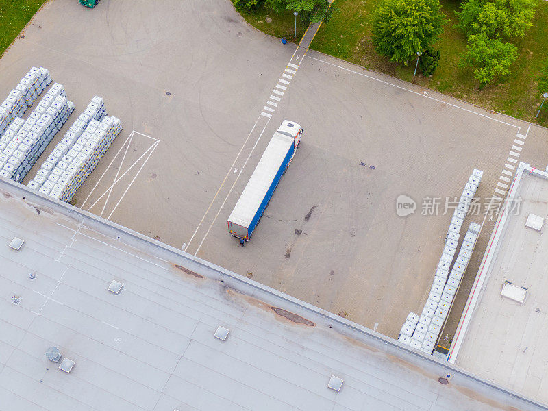 货仓鸟瞰图。物流中心在工业城区上空配送。在物流中心装货的卡车鸟瞰图