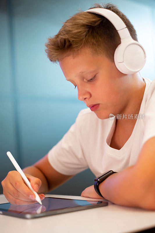 十几岁的男孩在平板电脑上画画