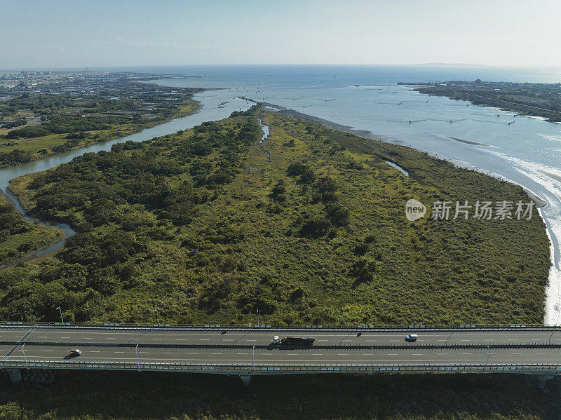 汽车在高速公路路口行驶的鸟瞰图。桥梁道路与绿色花园和树木连接的建筑概念