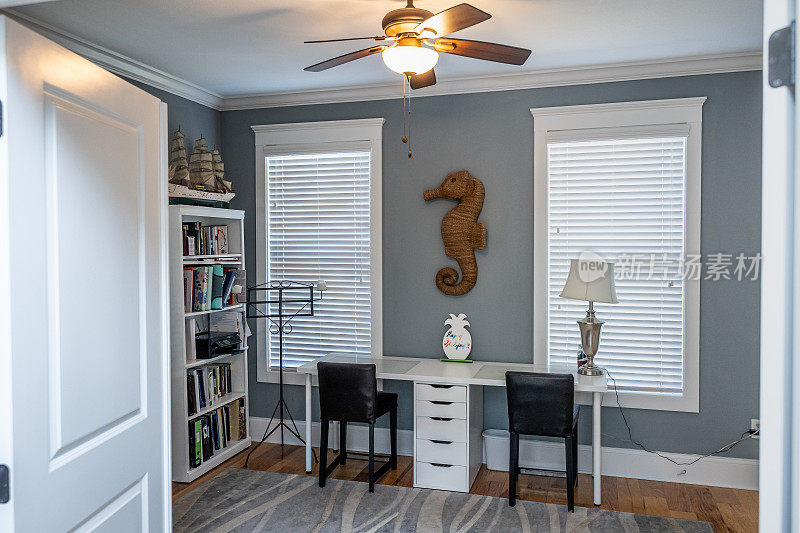 一间蓝色的空余卧室，用作家庭办公室或家庭学校自习室