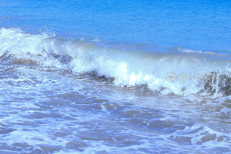 强大的海洋蓝色波浪与白色泡沫。美丽的蓝色水背景。沸腾的海浪。海里的巨浪。不安分的水。波涛汹涌的大海。波涛汹涌的大海，波涛汹涌