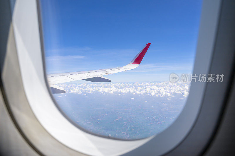 从飞机窗户看飞机机翼上的天空、大地、陆地、云。