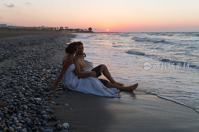 黄昏时分，一对新婚夫妇在朦胧的海滩上