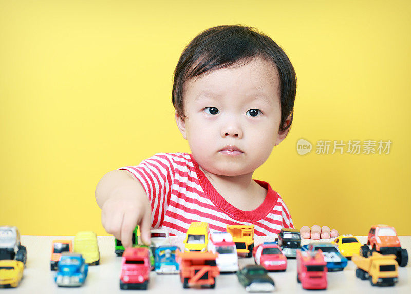 可爱的亚洲儿童玩玩具汽车