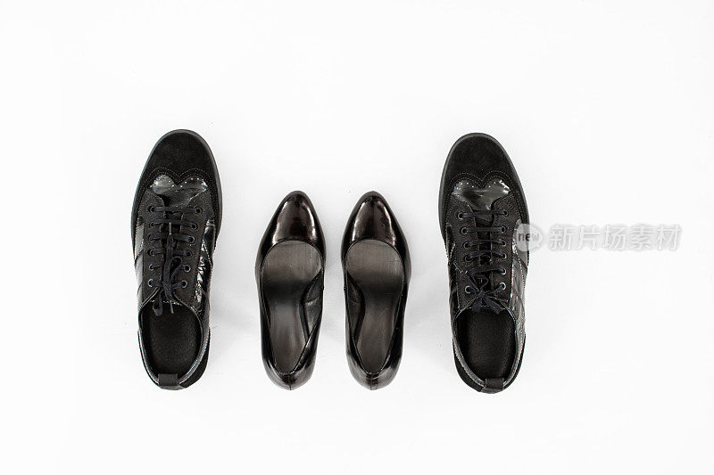 一双黑色女鞋，夹在两双黑色男鞋之间