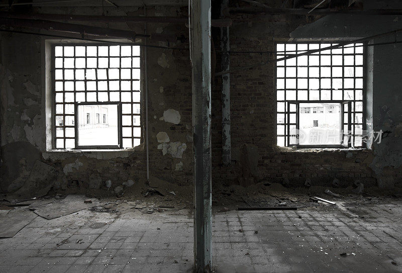 废弃的工厂大厅里的两扇旧窗户