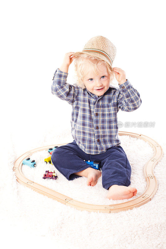 戴着帽子的小男孩和火车玩具