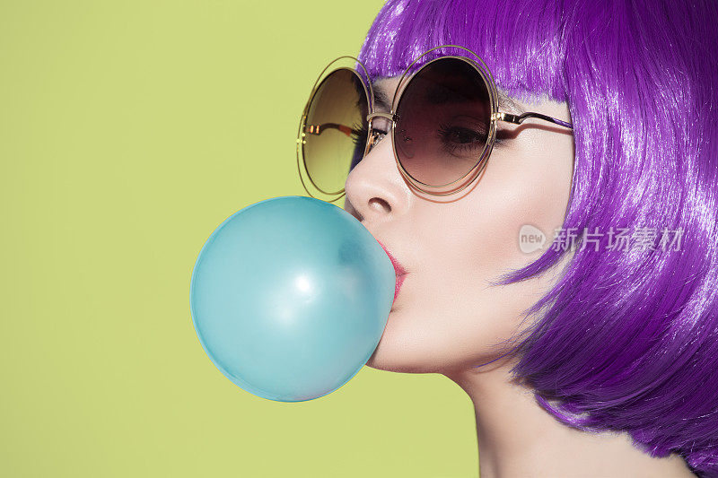 波普艺术女子肖像吹着蓝色的泡泡糖