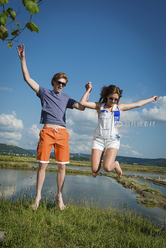 年轻情侣跳跃，夏季度假，地中海，欧洲
