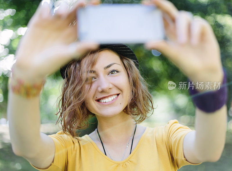 迷人的女孩在公园里自拍