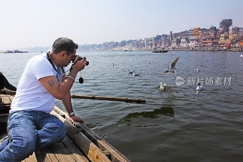在印度瓦拉纳西拍摄鸟类照片的游客