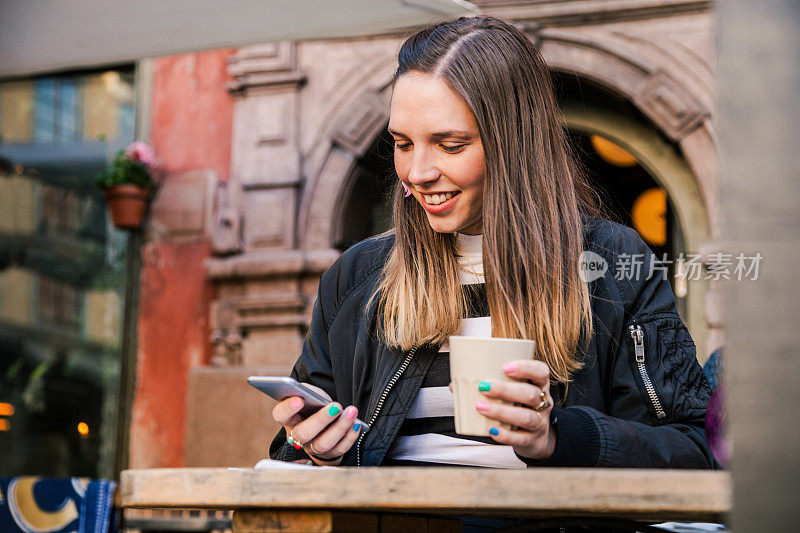 在路边咖啡馆喝咖啡的女人