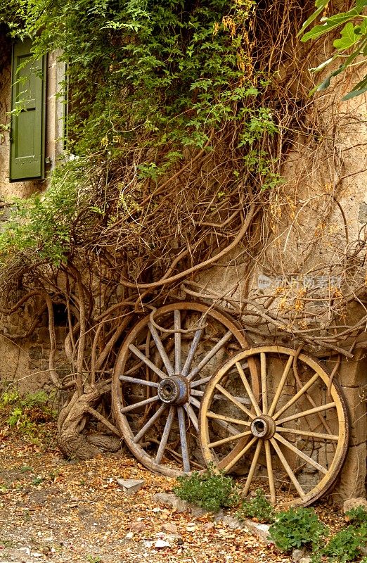 旧马车的轮子贴着粗糙的风化墙