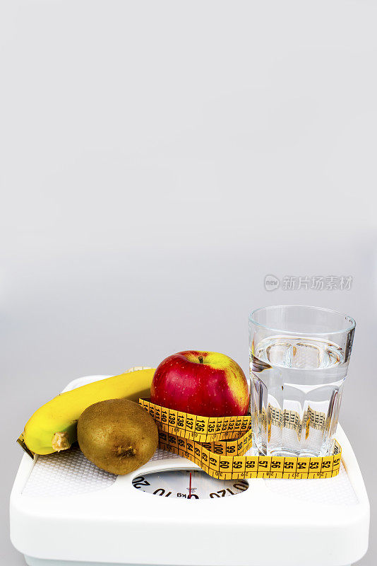 饮食的概念。苹果香蕉猕猴桃杯子水卷尺