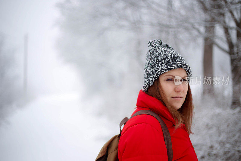 女徒步旅行者背包和雪鞋在雪地上的雪鞋