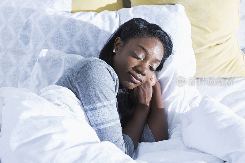 一个年轻的非洲裔美国女人在床上睡觉
