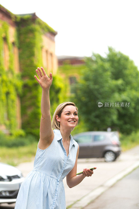 年轻女子拿着手机找出租车