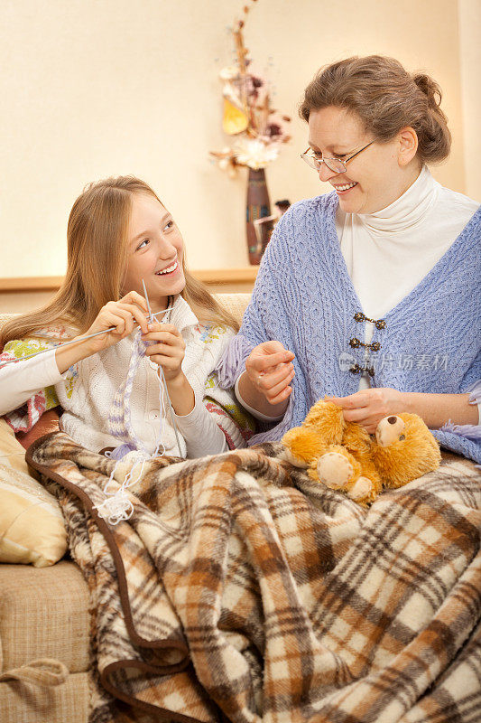 快乐的祖母和孙女缝纫，编织在家里