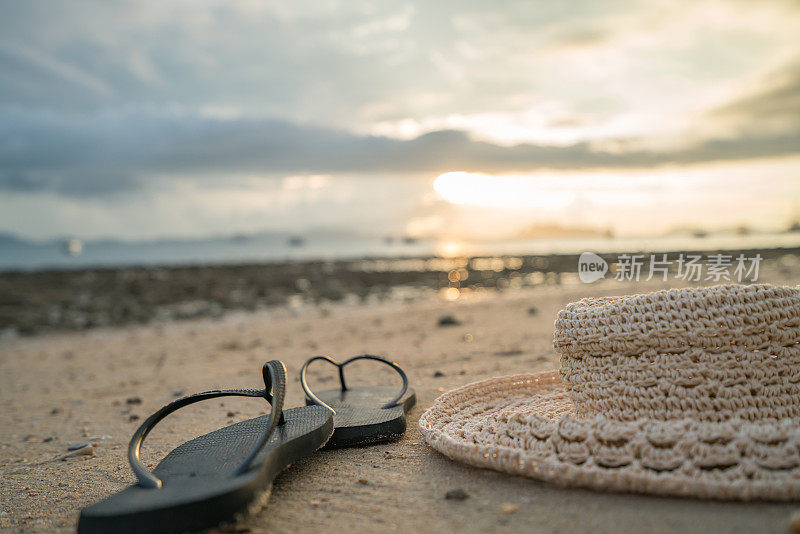 人字拖和太阳帽在沙滩上