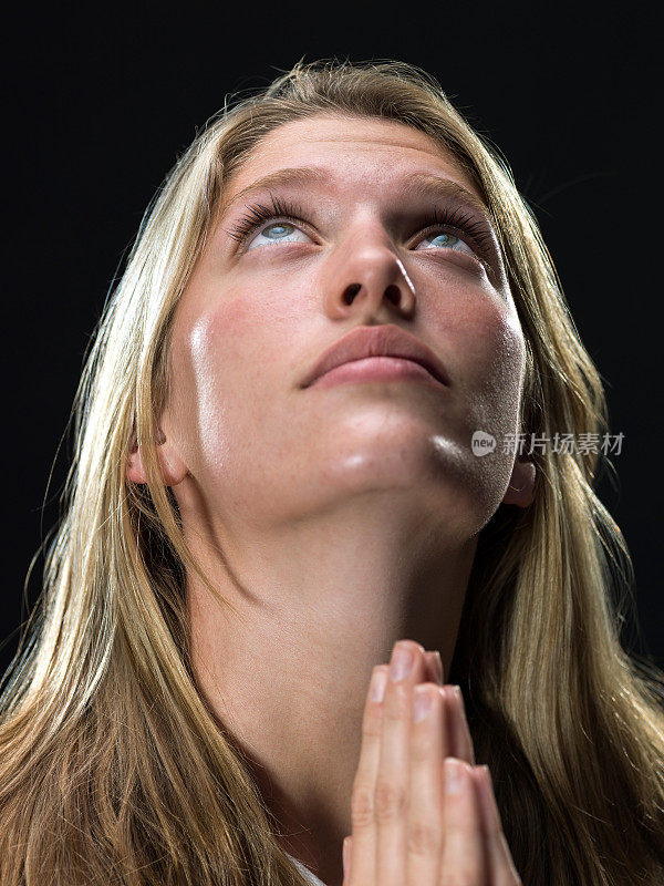 年轻的金发女人在祈祷