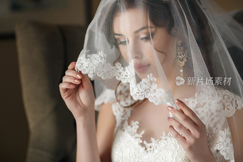 穿着白色婚纱和面纱的美丽新娘