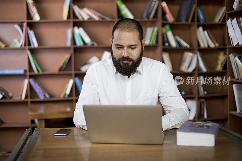 在图书馆使用笔记本电脑的商人