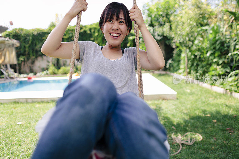 日本女游客喜欢荡秋千在手工制作的绳索