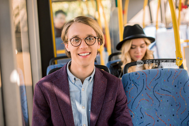 在公交车上戴眼镜的年轻人