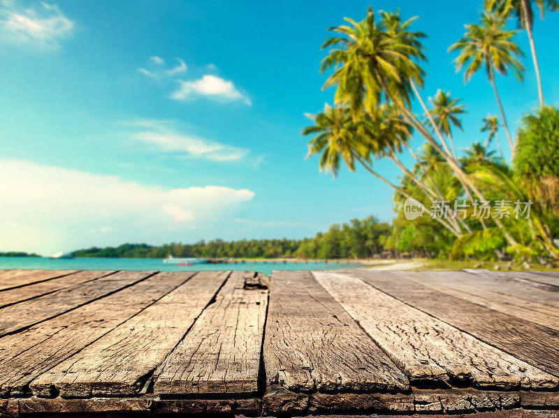 木头桌子与模糊的海洋和椰子树背景