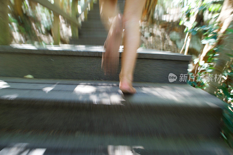 女孩跑上户外木台阶运动