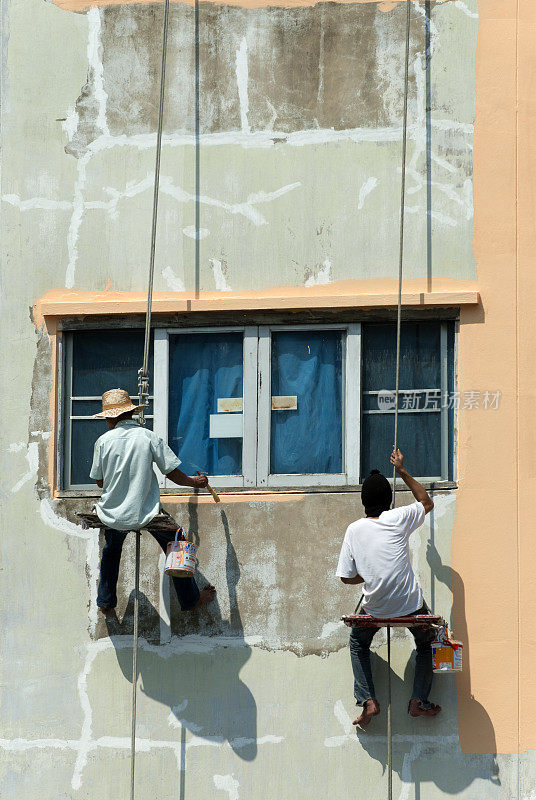 泰国曼谷，工人们正在粉刷房屋外墙