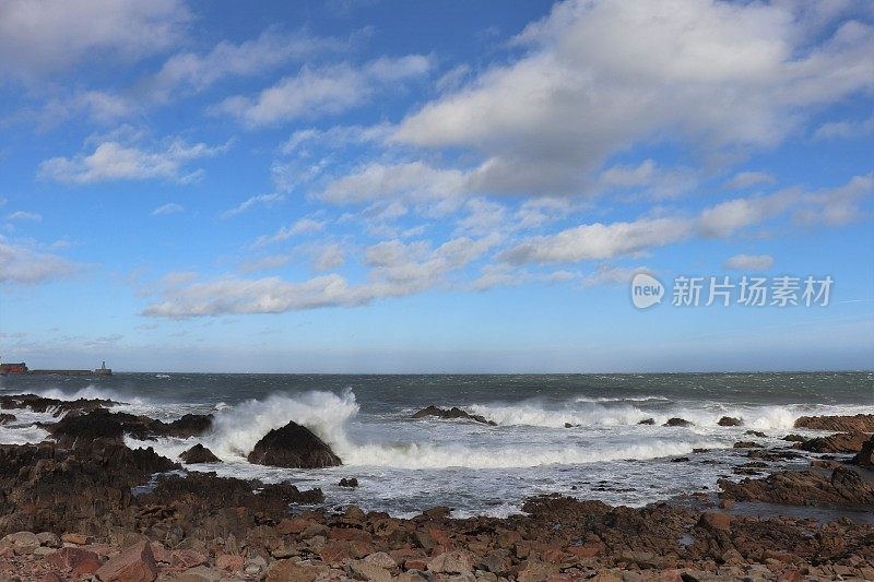 蓝天白云，海浪拍打着岩石